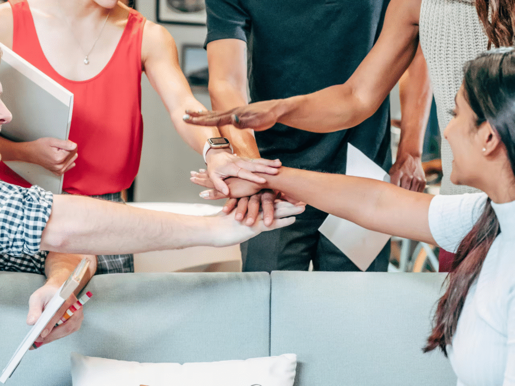co-workers putting their hands together as a gesture of teamwork and cooperation