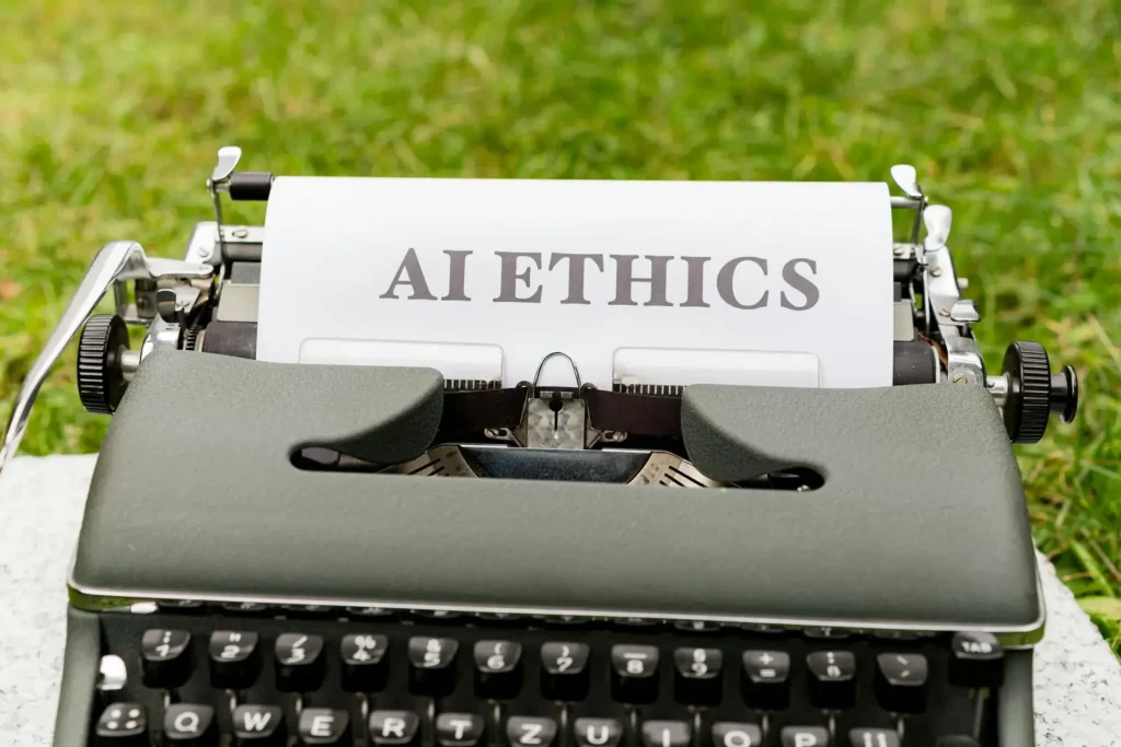 a typewriter with a piece of paper typed with the words "ai ethics", signifying how important ethics is to ai and business